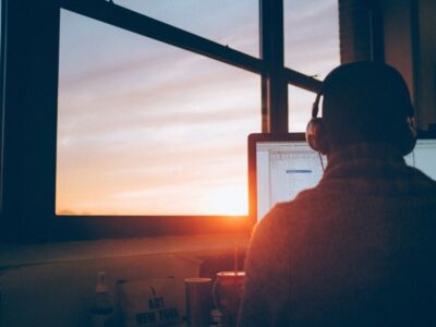 Man working on a computer at sunset